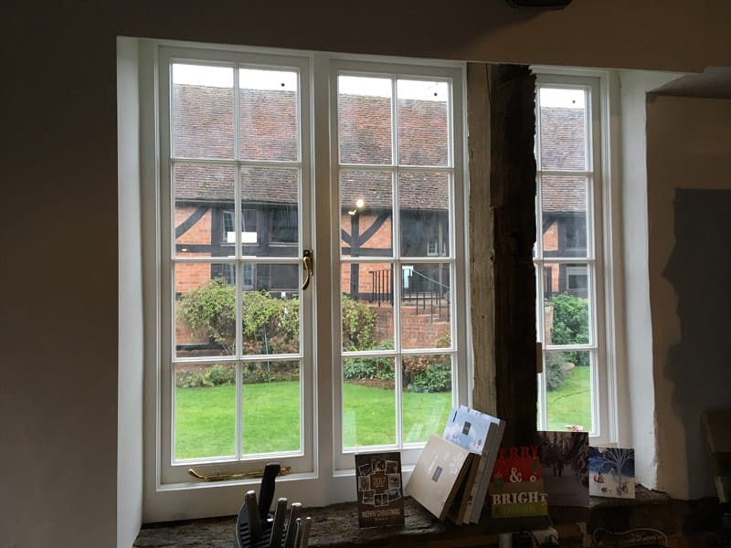Internal view of energy-efficient vacuum glazed casement windows in Kidderminster, showcasing garden views and the captivating historic listed building.