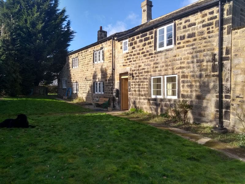 Historic stone farmhouse with upgraded timber windows featuring energy-efficient LandVac vacuum glazing, preserving the traditional character while improving insulation.