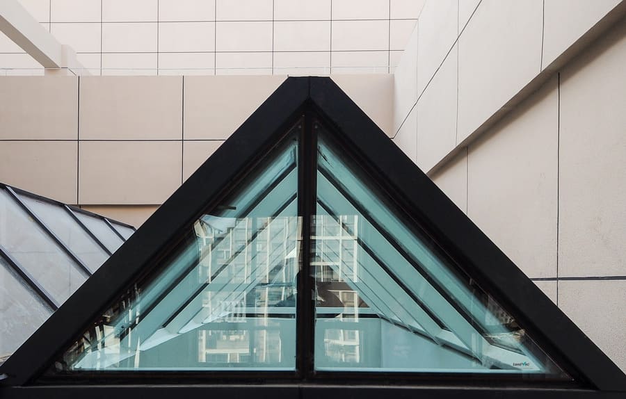 Straight-on view of a triangular roof lantern section using LandVac vacuum glazing, with black framing and reflective glass panes.